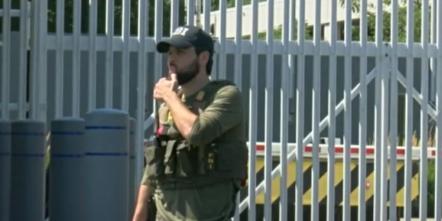 An FBI agent stands outside the scene of an exchange between law enforcement and FBI field office break-in suspect Ricky Shiffer.