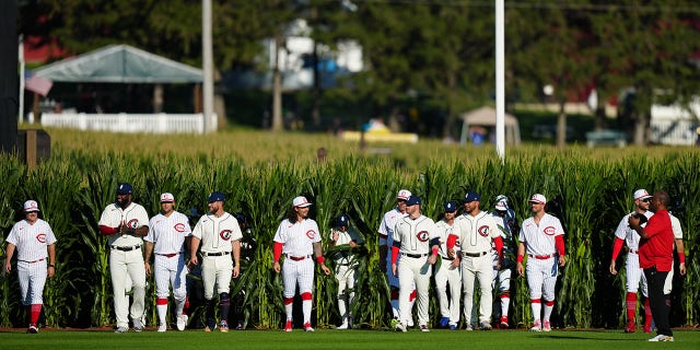 The Cincinnati Reds and Chicago Cubs emerge from the wheatfield for the game between the Chicago Cubs and Cincinnati Reds at The MLB Field at Field of Dreams on Thursday, August 11, 2022 in Dyersville, Iowa.