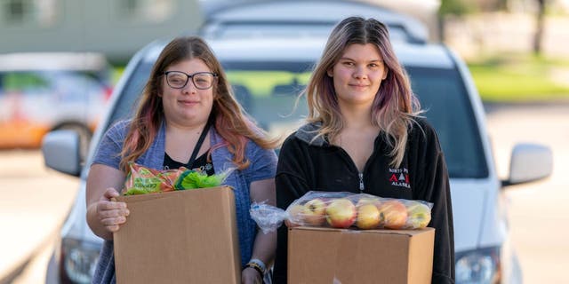 Two sisters receive food at Feeding South Dakota