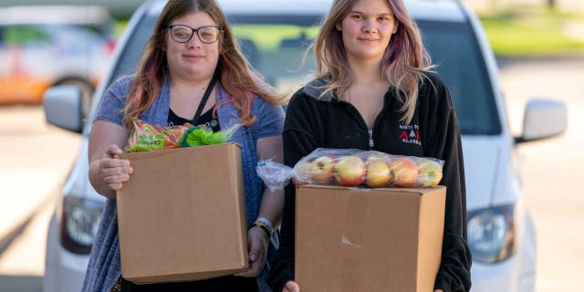 Two sisters receive food at Feeding South Dakota