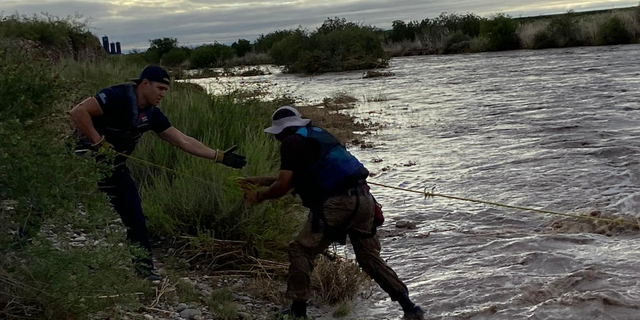 The driver is seen making his way onto shore.