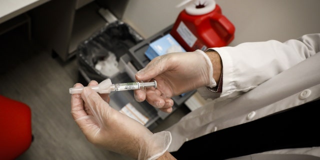 A pharmacist prepares a free flu shot vaccine at a CVS Health Corp. Pharmacy in Miami, Florida, U.S., on Wednesday, Sept. 30, 2020.