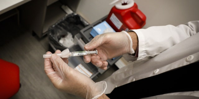 A pharmacist prepares a free flu vaccine at a CVS Health Corp. pharmacy in Miami, Florida, USA, Wednesday, September 30, 2020. 