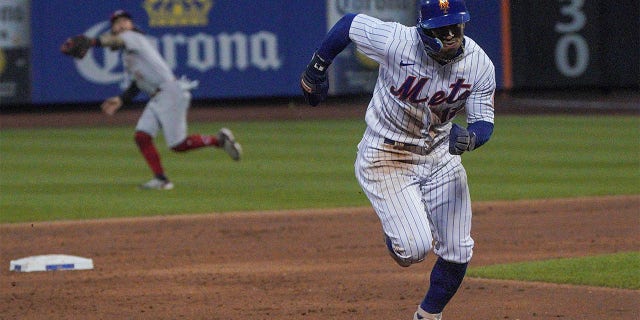New York Mets' Francisco Lindor runs from second base to score aa run during the third inning of a baseball game against the Cincinnati Reds, Monday, Aug. 8, 2022, in New York.