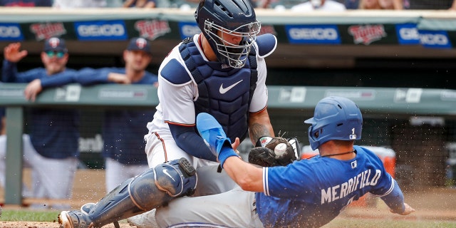 Minnesota Twins catcher Gary Sanchez tags out Toronto Blue Jays' Whit Merrifield, who tagged from third on a sacrifice fly by Cavan Biggio, during the 10th inning in Minneapolis on Aug. 7, 2022.
