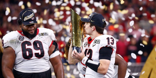 Georgia Bulldogs QB Stetson Bennett (13) kisses the national championship trophy after defeating the Alabama Crimson Tide in the College Football Playoff national championship Jan. 10, 2022, at Lucas Oil Stadium in Indianapolis.