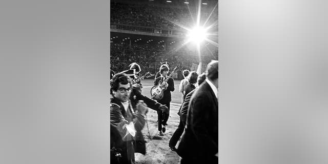 San Francisco, California, on August 29, 1966: George Harrison (center) and Ringo Starr (partially obscured) plus the rest of The Beatles walk onto the infield of Candlestick Park for their last paid public concert. 