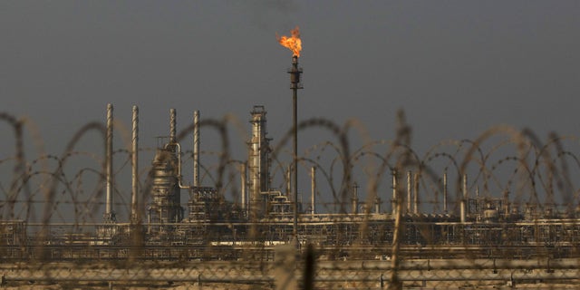 A flame burns off waste gas at Saudi Aramco's Ras Tanura oil refinery and terminal in Ras Tanura, Saudi Arabia.