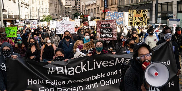 Black Lives Matter protesters march through a downtown street on June 14, 2020 in Seattle, United States.