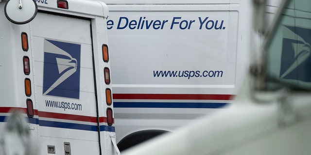 A U.S. Postal Service (USPS) trucks sit at a post office facility in Elkridge, Maryland. Authorities in California said more than 80 people have been charged in connection with stealing nearly $5 million in a fraud scheme involving the mail.