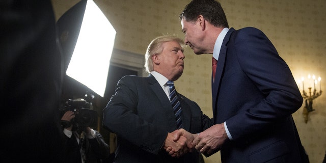 Jan 22, 2017: U.S. President Donald Trump, left, shakes hands with James Comey, director of the Federal Bureau of Investigation (FBI), during an Inaugural Law Enforcement Officers and First Responders Reception in the Blue Room of the White House in Washington, D.C.