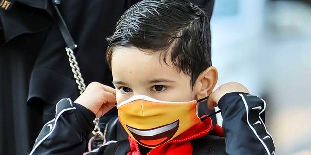 A student puts on a mask at Philip Rogers Elementary School in Chicago, on Aug. 30, 2021.