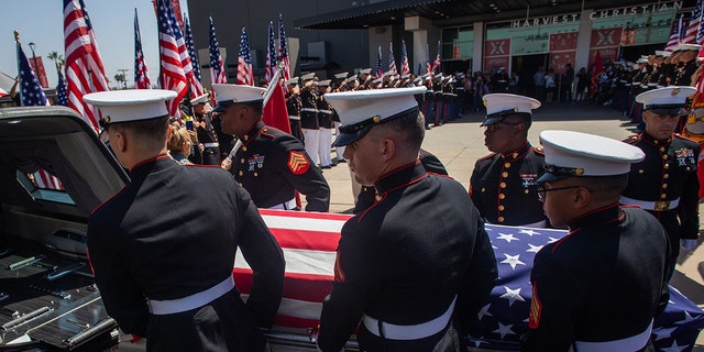 A military honor guard carries the flag-draped casket of Marine Lance Cpl. Kareem Grant Nikoui at the Harvest Christian Fellowship on Sept. 18, 2021, in Riverside, California.