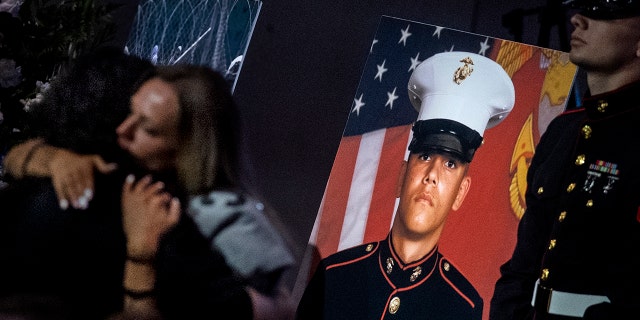 Shana Chappell, mom of slain Marine Lance Cpl. Kareem Nikoui, is embraced during a celebration of life service for him at Harvest Christian Fellowship Church, Riverside, on Sept. 18, 2021.