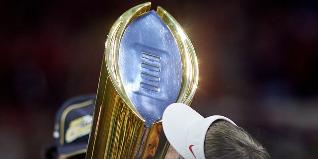 Georgia Bulldogs head coach Kirby Smart holds the national championship trophy after defeating the Alabama Crimson Tide in the College Football Playoff national championship Jan 10, 2022, at Lucas Oil Stadium in Indianapolis.
