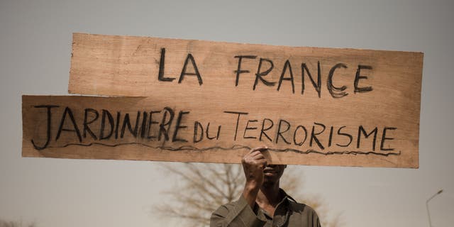 Un manifestant tient une pancarte lisant "La France, jardinière du terrorisme" lors d'une manifestation célébrant les plans de la France de retirer ses troupes du Mali, à Bamako, le 19 février 2022. Les dernières troupes françaises sont parties cette semaine.  (Florent Vergnes/AFP via Getty Images)
