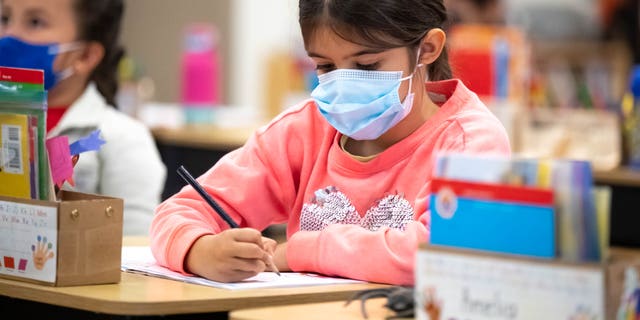 Students in Isabel Reyes kindergarten class at Stanley Mosk Elementary School in Winnetka, California, wear masks while indoors Friday, March 11, 2022. 