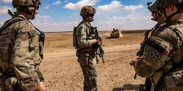 Miembros de las fuerzas de operaciones especiales de las Fuerzas Democráticas Sirias (SDF) y la coalición antiyihadista liderada por Estados Unidos participan en una maniobra militar con armas pesadas en el campo de Deir Ezzor, noreste de Siria, el 25 de marzo de 2022. 
