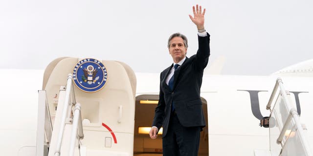 Secretary of State Anthony Brinken waves as he boards a plane leaving Algiers, Algeria, on March 30, 2022.