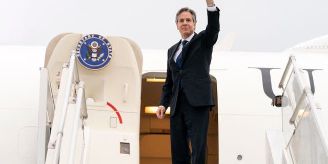 Secretary of State Anthony Brinken waves as he boards a plane leaving Algiers, Algeria, on March 30, 2022.