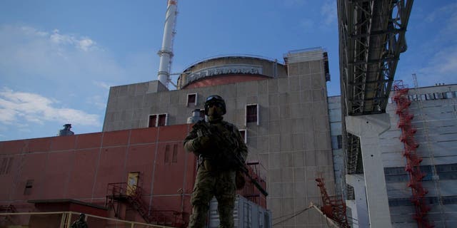A Russian serviceman stands guard the territory outside the second reactor of the Zaporizhzhia Nuclear Power Station in Energodar on May 1, 2022. 