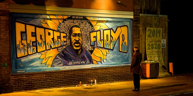 A woman looks at a mural on the wall of Cup Foods during a vigil for George Floyd on May 25, 2022, in Minneapolis, Minnesota, two years after his death. 