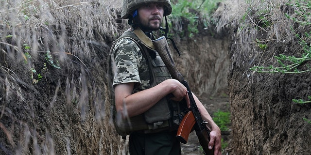 A Ukrainian serviceman Petro, 32, walks in a trench on a position held by the Ukrainian army between southern cities of Mykolaiv and Kherson on June 12, 2022, amid the Russian invasion of Ukraine. 