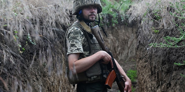 A Ukrainian military man Petro, 32, walks into a trench at a location held by the Ukrainian army between the southern cities of Mykolaiv and Kherson on June 12, 2022, during the Russian invasion of Ukraine. 