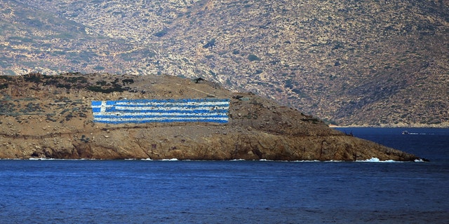 The Greek flag painted on a hill on Pserimos Island. Turkey claims Greece is violating international treaties by what it says is its militarization of its Islands in the eastern Aegean Sea.