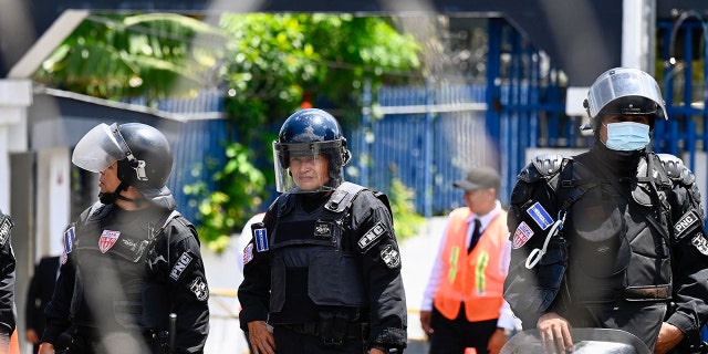 A policeman is photographed at the gates of the legislative assembly in San Salvador, El Salvador, on July 26, 2022. Carlos Castro left to escape civil war in his native land.