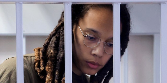 US basketball player Brittney Griner stands in a defendants' cage before a court hearing during her trial on charges of drug smuggling, in Khimki, outside Moscow on August 2, 2022. - Griner was detained at Moscow's Sheremetyevo airport in February 2022 just days before Moscow launched its offensive in Ukraine. She was charged with drug smuggling for possessing vape cartridges with cannabis oil. Speaking at the trial on July 27, Griner said she still did not know how the cartridges ended up in her bag. (Photo by EVGENIA NOVOZHENINA / POOL / AFP) (Photo by EVGENIA NOVOZHENINA/POOL/AFP via Getty Images)