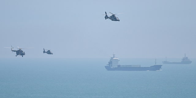 Chinese military helicopters fly past Pingtan island, one of mainland China's closest point from Taiwan, in Fujian province on August 4, 2022, ahead of massive military drills off Taiwan. 
