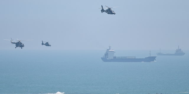 Des hélicoptères militaires chinois survolent l'île de Pingtan, l'un des points les plus proches de la Chine continentale depuis Taïwan, dans la province du Fujian le 4 août 2022, avant des exercices militaires massifs au large de Taïwan après la visite de la présidente de la Chambre des États-Unis, Nancy Pelosi, sur l'île autonome.