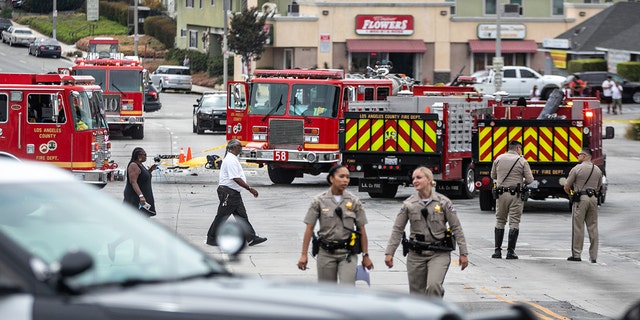 Members of the Los Angeles County Fire Department, CHP and other officials investigate a fiery crash where multiple people were killed near a Windsor Hills gas station at the intersection of West Slauson and South La Brea avenues on Thursday, Aug. 4, 2022 in Los Angeles, CA. 