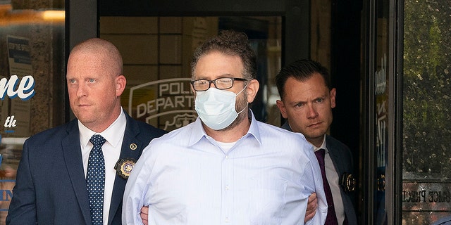 Glenn Hirsch is walked from the New York Police Department 112th Precinct station house on Thursday, June 2, 2022, in Queens, New York. 