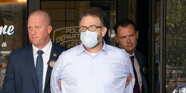 Glenn Hirsch is walked from the New York Police Department 112th Precinct station house on Thursday, June 2, 2022, in Queens, New York.