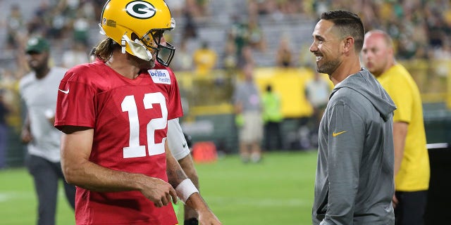 Green Bay Packers quarterback Aaron Rodgers (12) and Green Bay Packers head coach Matt LaFleur share a laugh during Green Bay Packers Family Night at Lambeau Field, Aug. 5, 2022, in Green Bay, Wis.