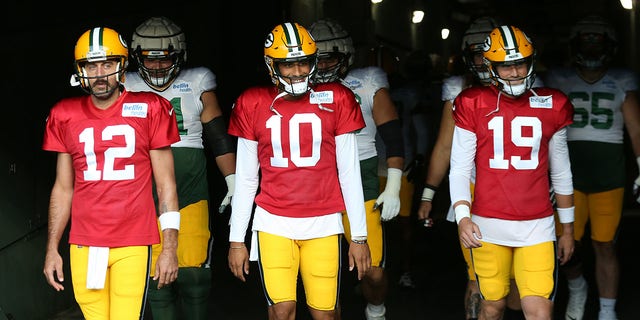 Green Bay Packers quarterbacks Aaron Rodgers (12), Jordan Love (10) and Danny Etling (19) walk onto the field during Green Bay Packers Family Night at Lambeau Field, Aug. 5, 2022, in Green Bay, Wis. 