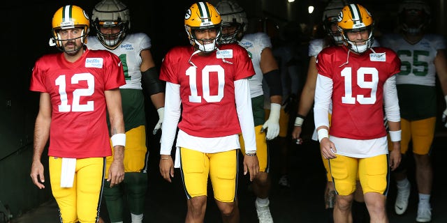 Green Bay Packers quarterbacks Aaron Rodgers (12), Jordan Love (10) and Danny Etling (19) walk onto the field during Green Bay Packers Family Night at Lambeau Field, Aug. 5, 2022, in Green Bay, Wis.