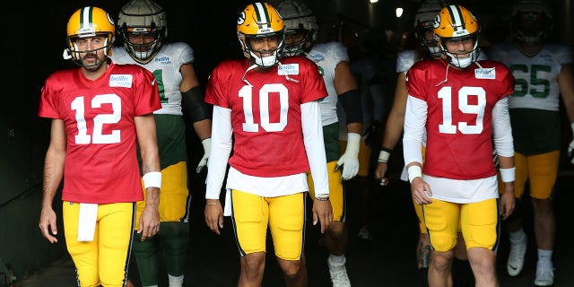 Green Bay Packers quarterbacks Aaron Rodgers (12), Jordan Love (10) and Danny Etling (19) walk onto the field during Green Bay Packers Family Night at Lambeau Field, Aug. 5, 2022, in Green Bay, Wis. 