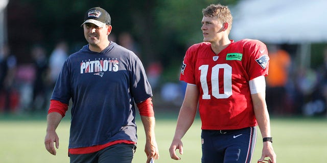 Patriots quarterback Mac Jones, right, walks off the practice field with quarterbacks coach Joe Judge during training camp in Foxborough, Massachusetts.