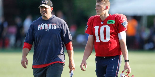 Patriots quarterback Mac Jones, right, walks off the practice field with quarterbacks coach Joe Judge during training camp in Foxborough, Massachusetts.