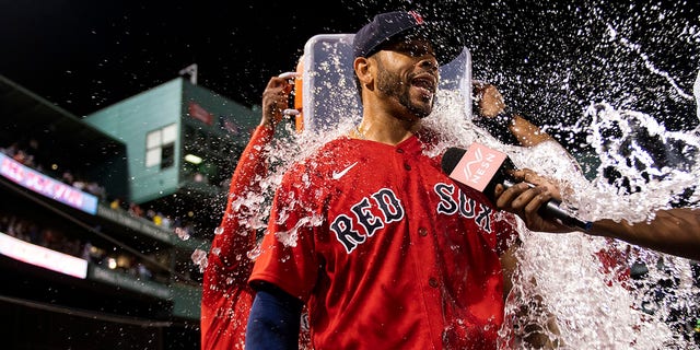 Tommy Pham (22) of the Boston Red Sox is doused with water after hitting a game-winning walk-off RBI single during the 10th inning against the New York Yankees Aug. 12, 2022, at Fenway Park in Boston.