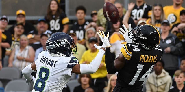 George Pickens #14 of the Pittsburgh Steelers makes a catch for a 26-yard touchdown reception as Coby Bryant #8 of the Seattle Seahawks defends in the first quarter during a preseason game at Acrisure Stadium on August 13, 2022 in Pittsburgh, Pennsylvania. 