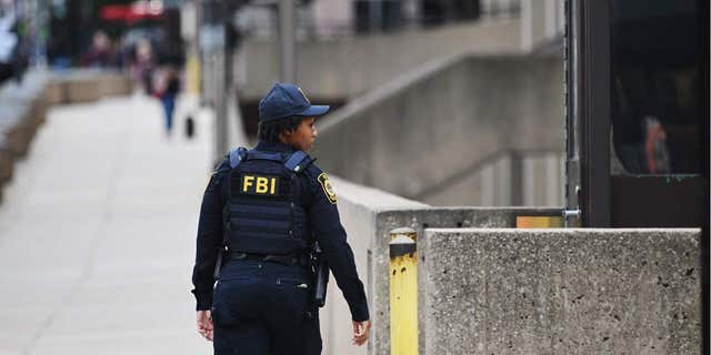 Security personnel patrol around the headquarters of the Federal Bureau of Investigation (FBI) in Washington, DC.  