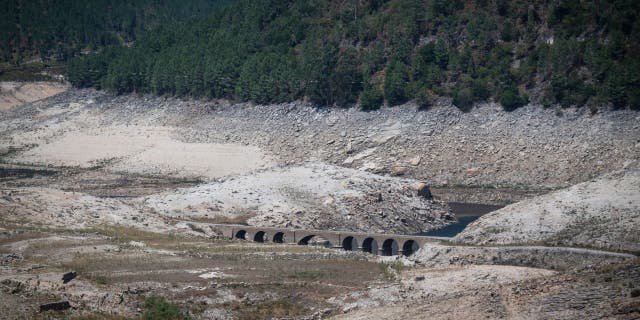   The normally submerged bridge of the former Aceredo village emerged after surfacing due to the low water level of the Lindoso reservoir, near Lobios, Ourense province, northwestern Spain, on 25 August 2022. 