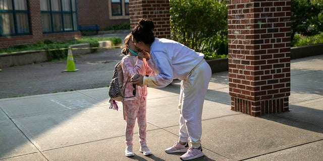 A mother kisses her daughter while dropping her off for class at Stark Elementary School on September 16, 2020. in Stamford, Connecticut. 