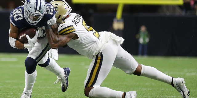 Tony Pollard, #20 of the Dallas Cowboys, is tackled by Kwon Alexander, #5 of the New Orleans Saints, in the second quarter of the game at Caesars Superdome on December 02, 2021 in New Orleans, Louisiana.