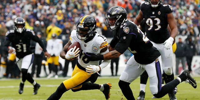 Deontay Johnson #18 of the Pittsburgh Steelers is tackled by Jimmy Smith #22 of the Baltimore Ravens during the second quarter at M&T Bank Stadium on January 9, 2022 in Baltimore, Maryland.