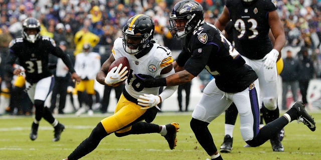Diontae Johnson #18 of the Pittsburgh Steelers is tackled by Jimmy Smith #22 of the Baltimore Ravens during the second quarter at M&T Bank Stadium on Jan. 9, 2022 in Baltimore, Maryland.